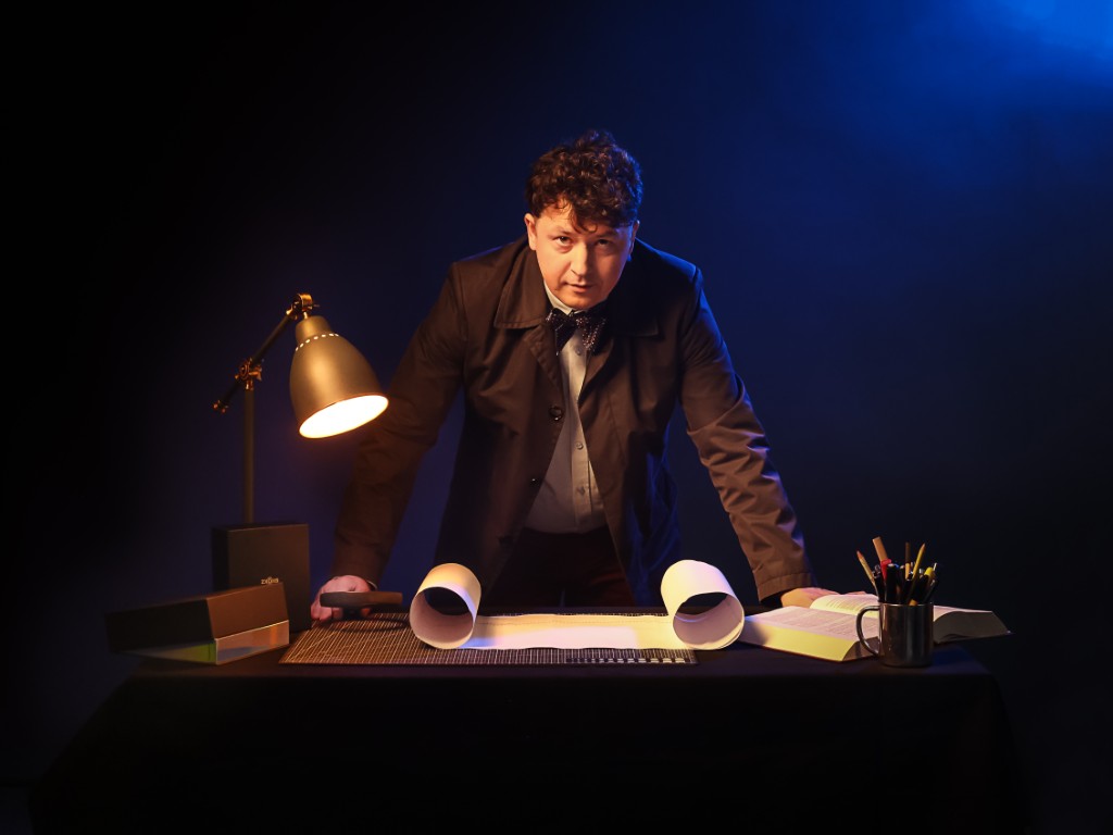 Michał Siejda opiera ręce na biurku i patrzy przed siebie