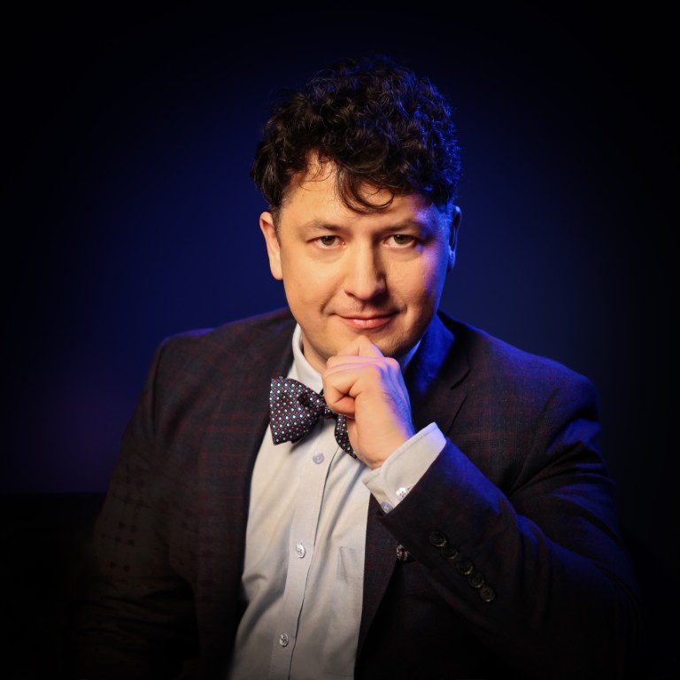 Michał Siejda podpiera ręką brodę i patrzy przed siebie